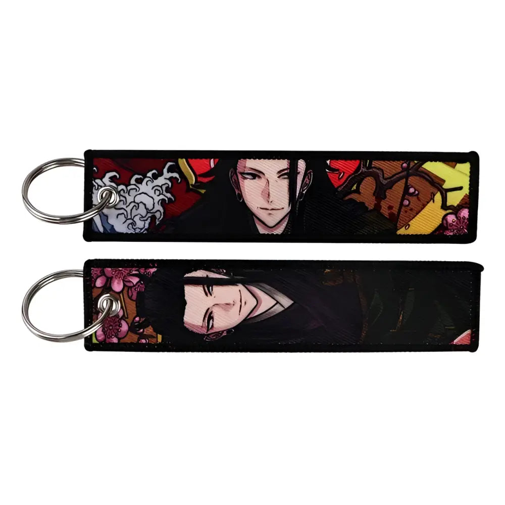 Two black fabric jujutsu kaisen gojo keychains with vibrant embroidery and silver metal rings for bag charm use