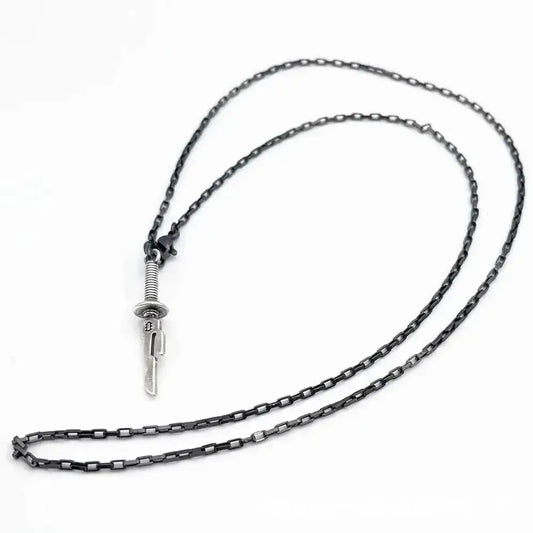 A sleek dark-toned chain necklace with a silver jujutsu kaisen toji fushiguro sword pendant featuring engraved blade and textured hilt