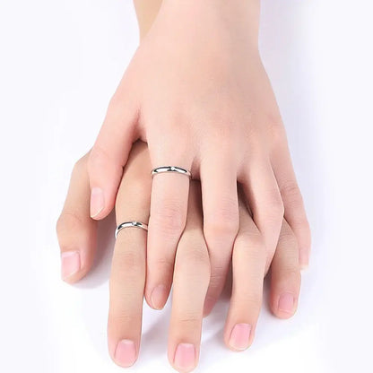 A pair of minimalist silver jujutsu kaisen yuta okkotsu cosplay rings with smooth bands worn on intertwined fingers