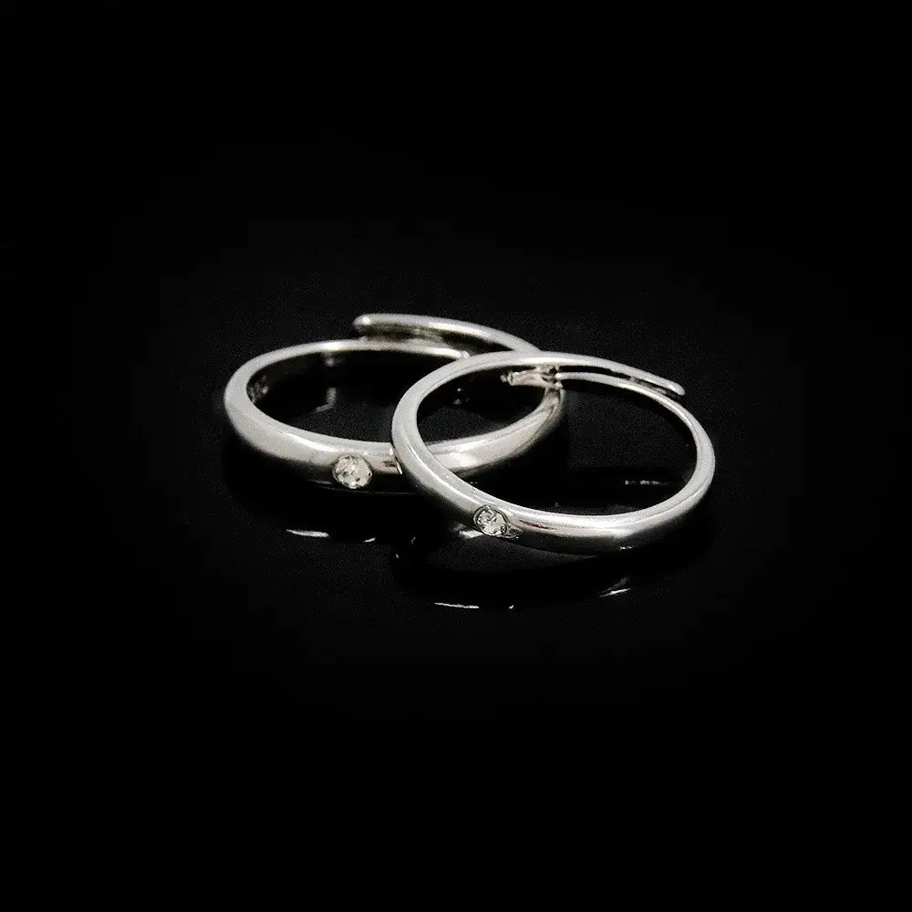 A pair of sleek silver hoop earrings with clear gemstones inspired by jujutsu kaisen yuta okkotsu couple ring jewelry