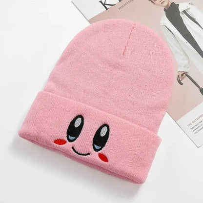 Pink kirby plush hat knit beanie with soft plush kawaii face featuring black eyes blue irises red cheeks and smile
