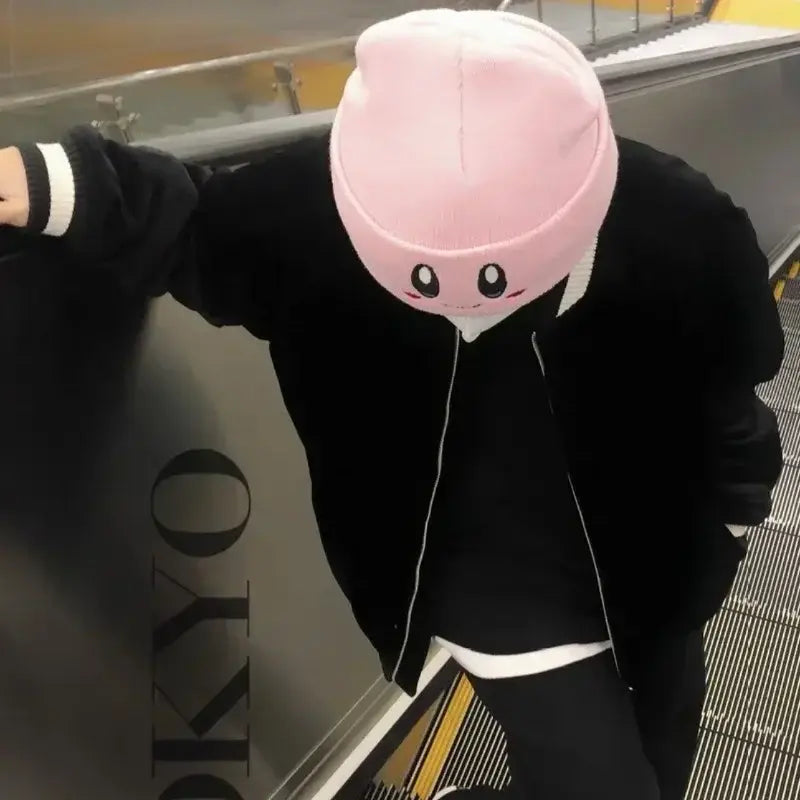 Pink kirby plush hat made of soft plush with kawaii embroidered face and smiling eyes for cozy wear