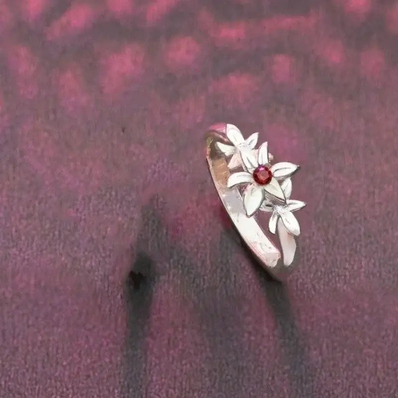 Delicate silver necklace pendant featuring three white flower motifs with a central red gemstone for cosplay accessory