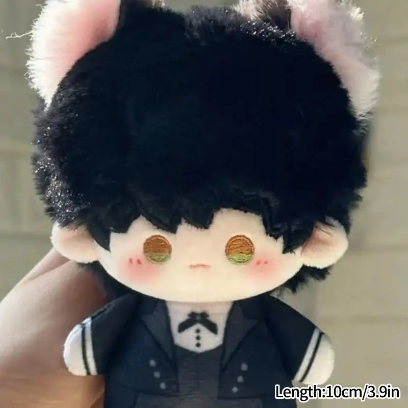 A cute cartoon plush doll keychain with black fluffy hair pink ears and golden eyes wearing a navy blue bag charm