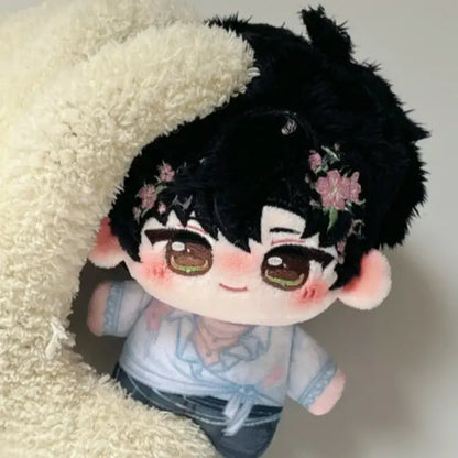A cute cartoon plush doll bag charm with black spiky hair, pink flowers, light blue shirt, and dark pants keychain