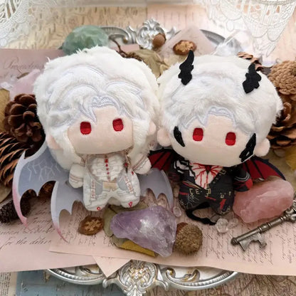 Two white plush dolls with red eyes and black bat wings as cute cartoon bag charm keychains in light and dark outfits