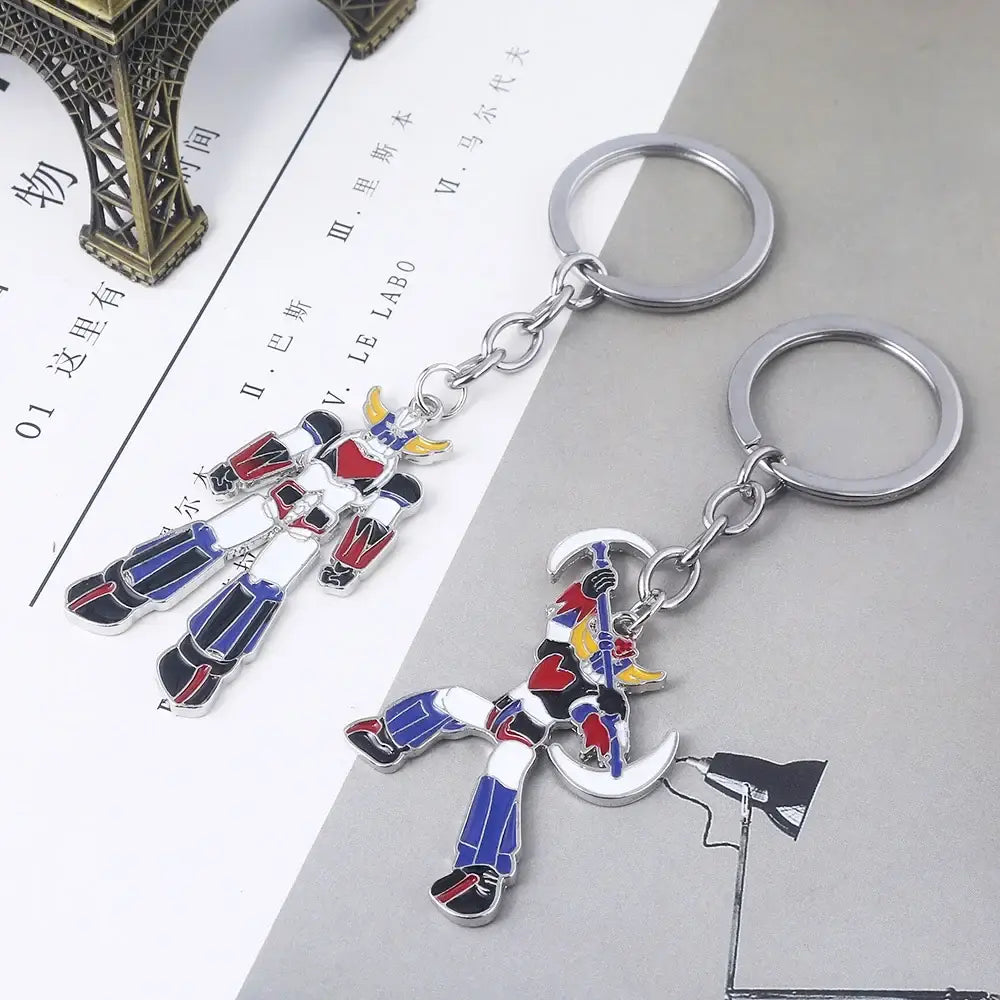 Two metallic keychains with colorful enamel bombarder logo robot figures and silver rings for car accessory use