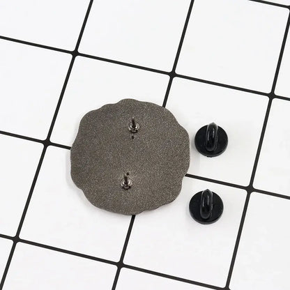 Back view of a dark gray scalloped-edge metal floating badge with textured surface and silver kageyama lapel pin fasteners