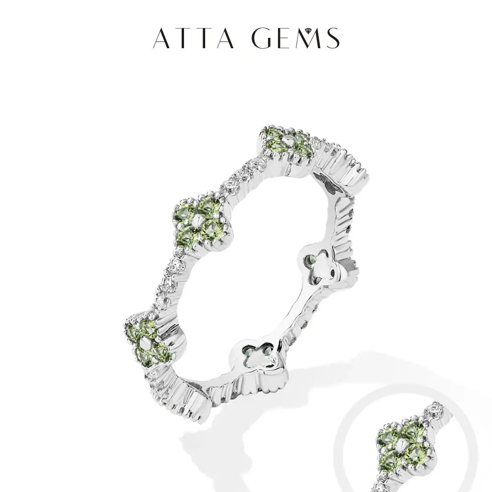 Moissanite eternity ring with intricate floral designs green gemstones and clear stones on sterling silver band