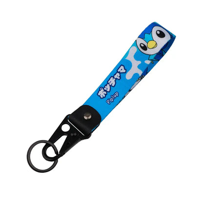 Blue fabric monster original keychain featuring cartoon piplup with white splashes and black text on a black carabiner