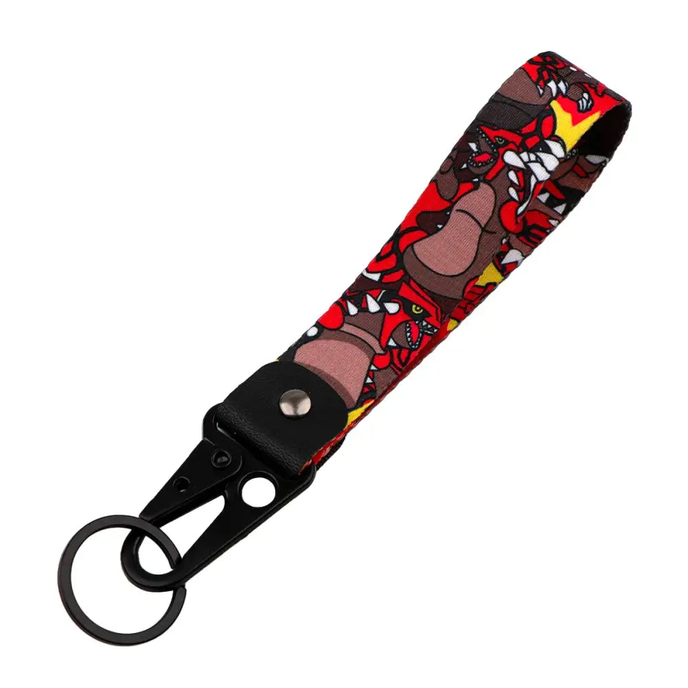 Red and black fabric monster original keychain with yellow anime monster design attached to black metal clip for car keys