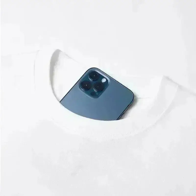 A sleek dark blue iphone 12 pro with triple camera peeking from the neckline of a white bakugo katsuki oversized t-shirt
