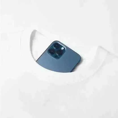 A sleek dark blue iphone 12 pro with triple camera peeking from the neckline of a white bakugo katsuki oversized t-shirt