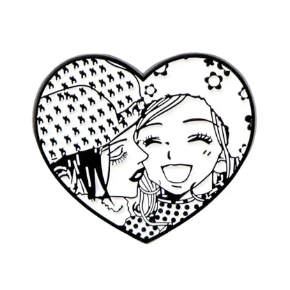 Heart-shaped nana oosaki enamel lapel pin with black and white anime girls kiss illustration on floral background