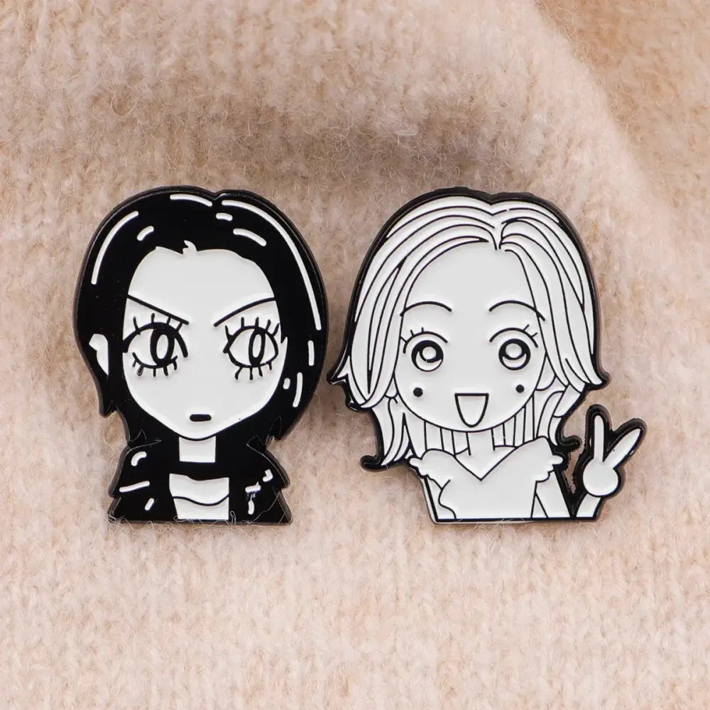 Two black and white nana oosaki enamel lapel pins featuring cartoon anime characters with detailed linework and glossy finish