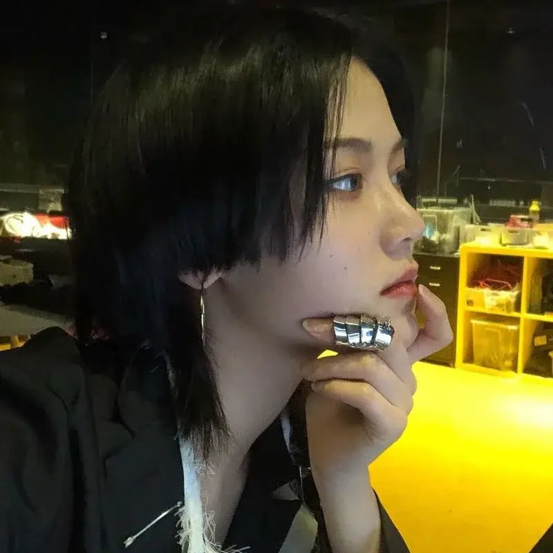 A wide chunky silver nana oosaki knuckle ring with a segmented geometric metal armor design for bold style