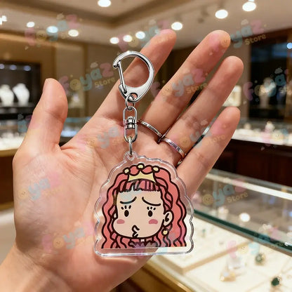 Clear acrylic keychain featuring nana osaki chibi girl with pink curly hair and crown attached to silver bag charm clasp