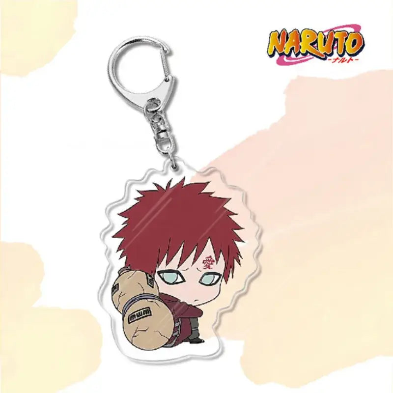 A clear acrylic naruto acrylic keychain featuring a chibi red-haired character holding a tan scroll bag charm accessory