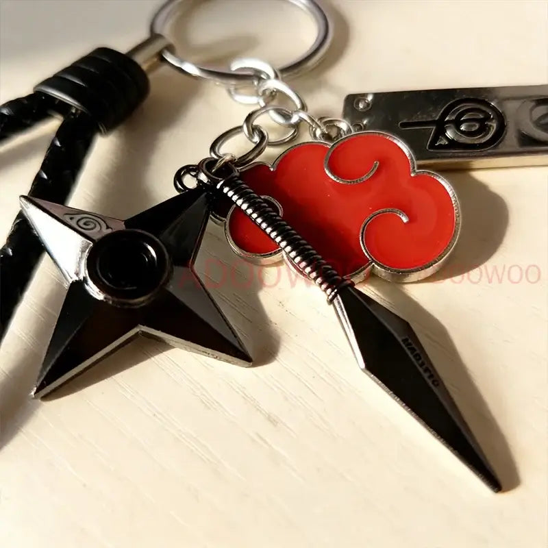Black and silver Naruto Akatsuki alloy keychain with star-shaped shuriken, red cloud emblem, and black tanto knife charm