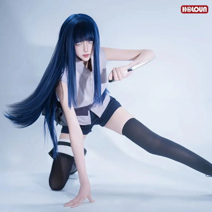 A cosplayer wearing a detailed blue hyuga hinata cosplay wig with a gray blouse, black shorts, and holding a prop knife