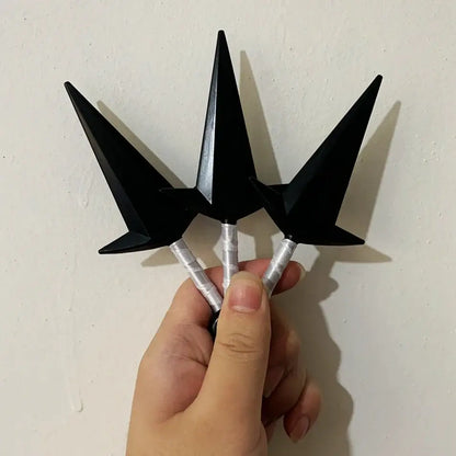 Hand holding three black pointed naruto kunai with silver handles from a naruto kunai cosplay set 3-piece ninja weapon set