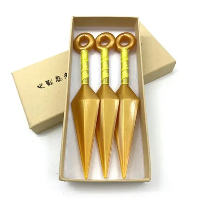 Three golden kunai model knives with yellow wrapped handles made of pvc neatly arranged in a beige box