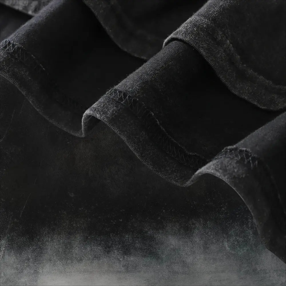 Black denim fabric with acid wash texture and visible stitching detail of naruto kurama oversized soft cotton t shirt