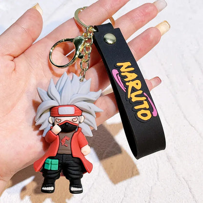 Gray-haired naruto pvc silicone keychain in red jacket with black wrist strap featuring yellow and pink naruto text