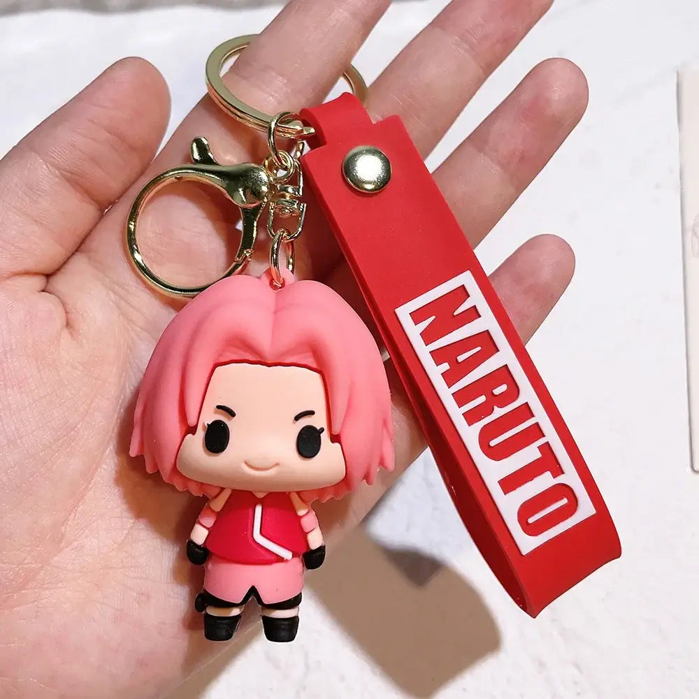 Pink pvc silicone keychain featuring chibi sakura haruno from naruto with red strap printed with naruto logo