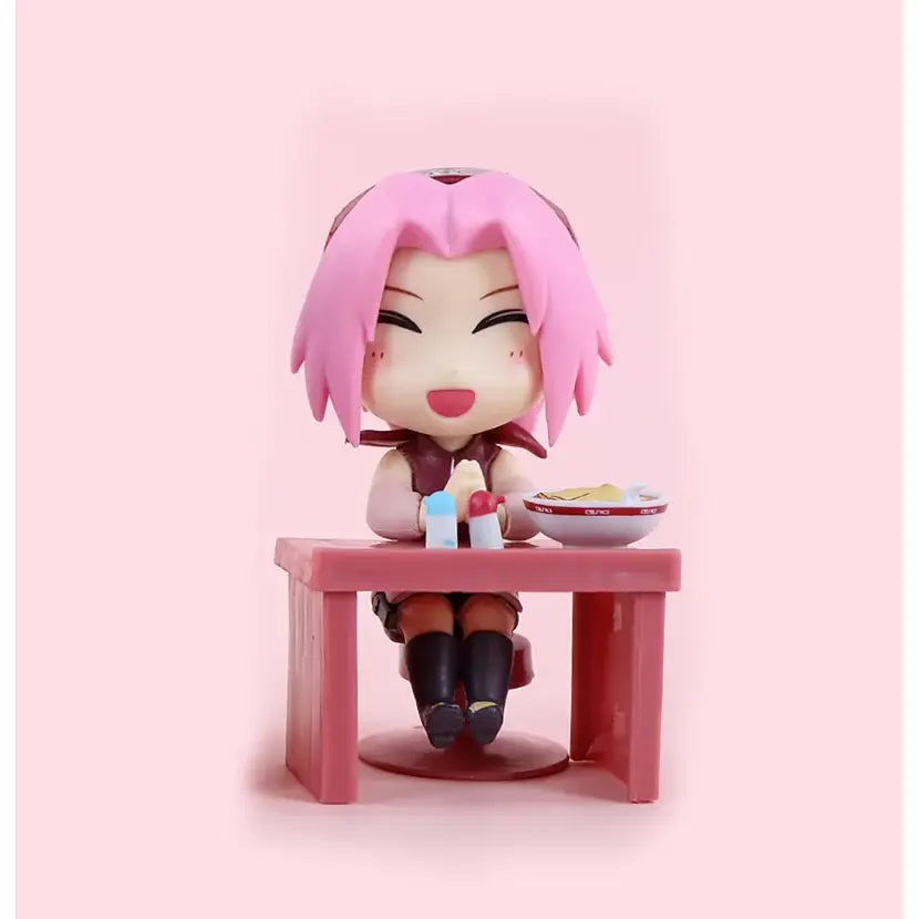 Pink-haired sakura figurine seated at matching pink table holding chopsticks in naruto sasuke blind box figure set