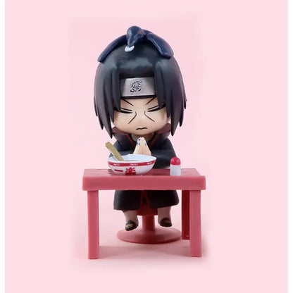 Black-haired naruto anime figurine with silver headband and dark robe seated at pink table holding white bowl from naruto sasuke blind box figure set