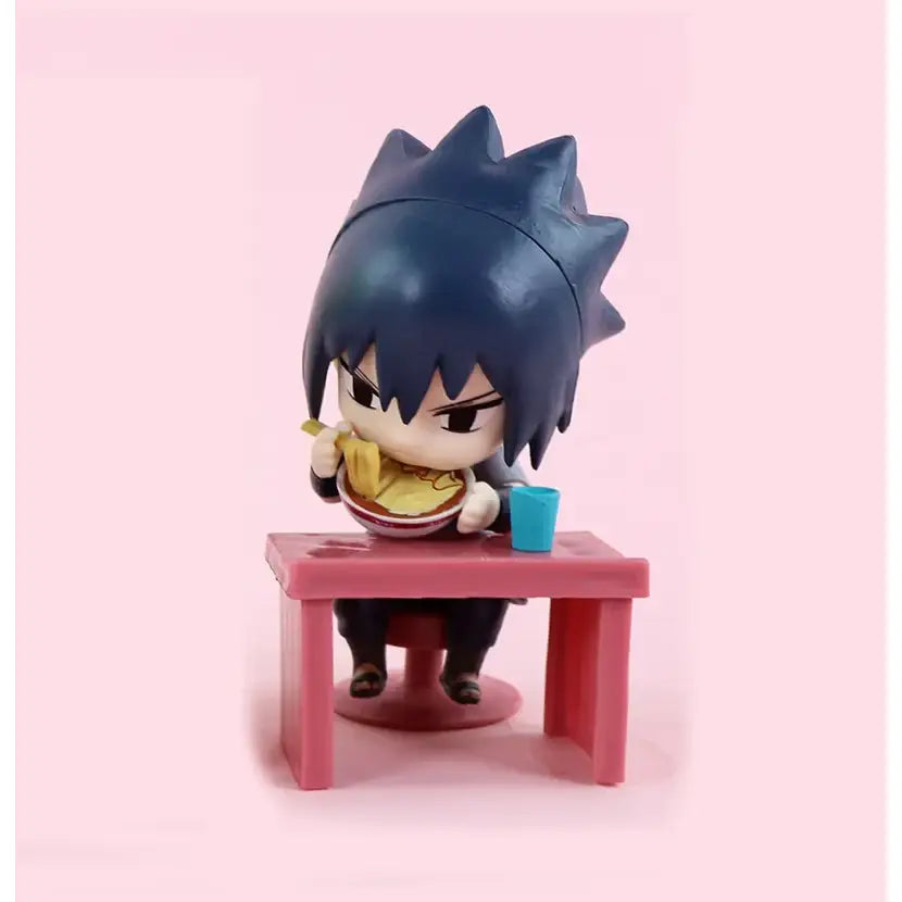 Chibi-style naruto blind box figure with spiky dark blue hair seated at pink plastic table holding bowl of noodles