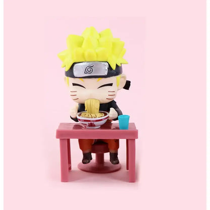 Chibi-style Naruto figure with spiky yellow hair seated at pink table eating noodles from white bowl in Naruto Sasuke set