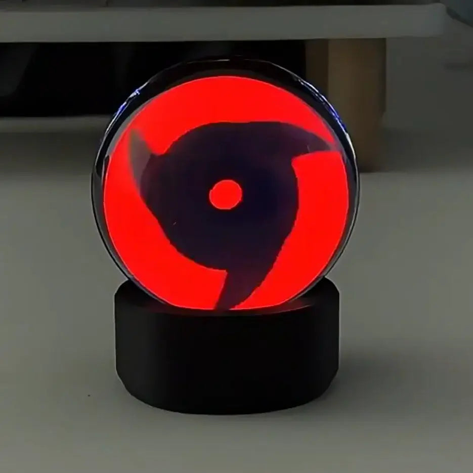 Red glowing led crystal night light featuring a black sharingan eye design in a clear glass dome on a black base