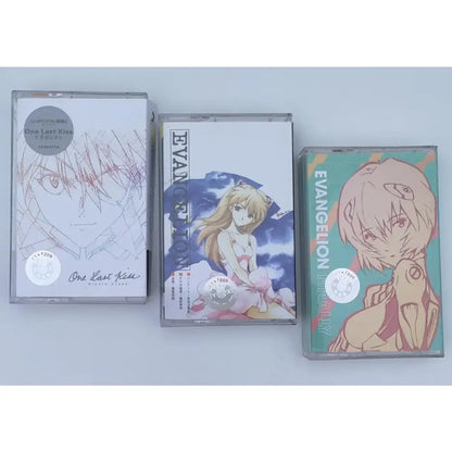 Three anime-themed cassette tapes in clear plastic cases featuring asuka langley soryu artwork from evangelion series