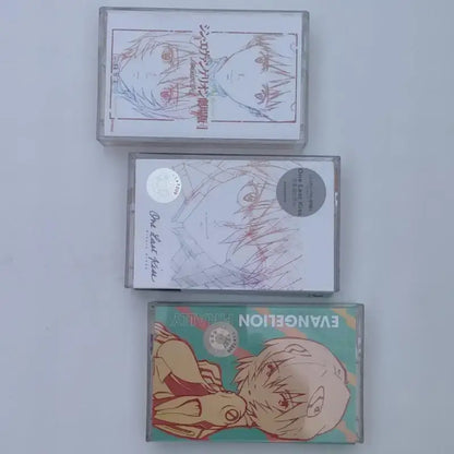 Three clear plastic cassette tapes featuring illustrated asuka langley soryu artwork from neon genesis evangelion soundtrack