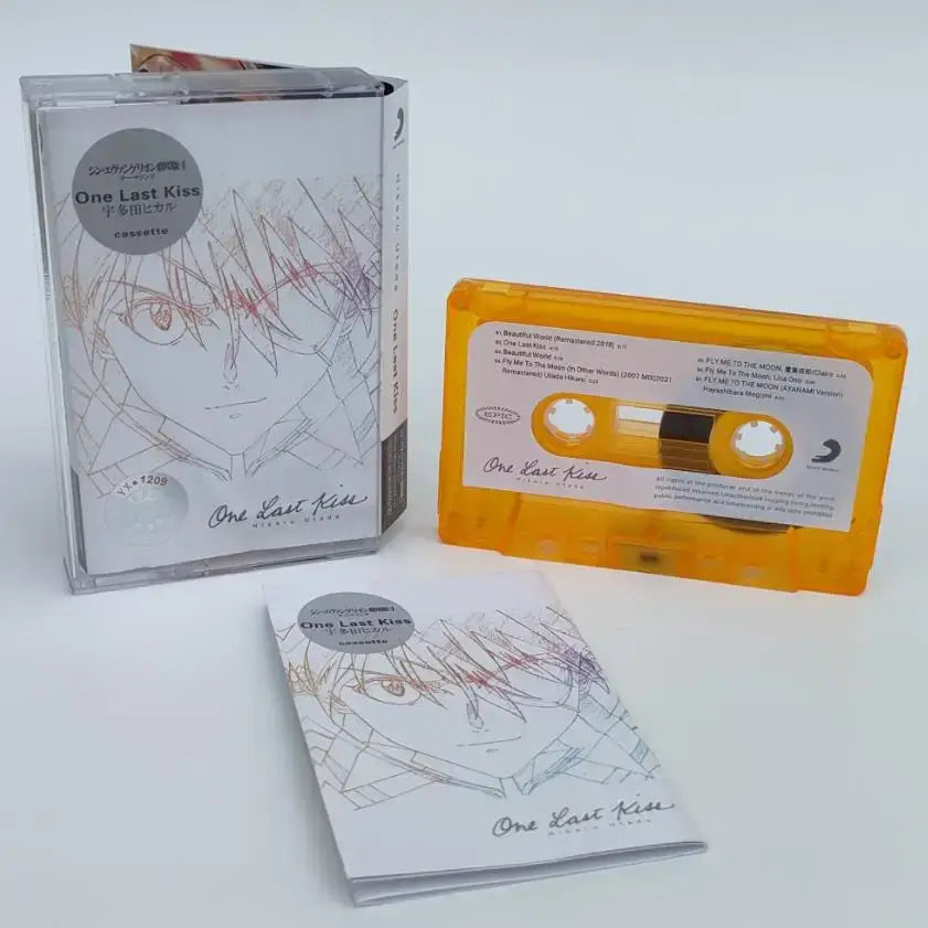 Vibrant yellow cassette tape with white label and anime-style asuka langley soryu illustration in clear case