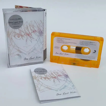 Vibrant yellow cassette tape with white label and anime-style asuka langley soryu illustration in clear case