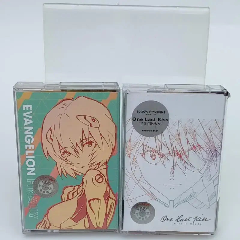 Two clear plastic cassette tapes with teal evangelion rei ayanami and white sketch shinji ikari artwork for neon genesis evangelion asuka langley soundtrack