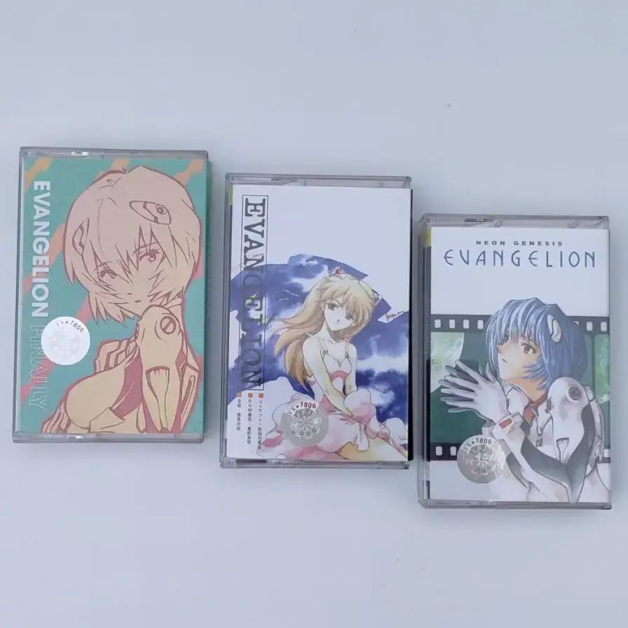 Three neon genesis evangelion asuka langley cassette tapes with anime artwork in clear plastic cases for one last kiss soundtrack