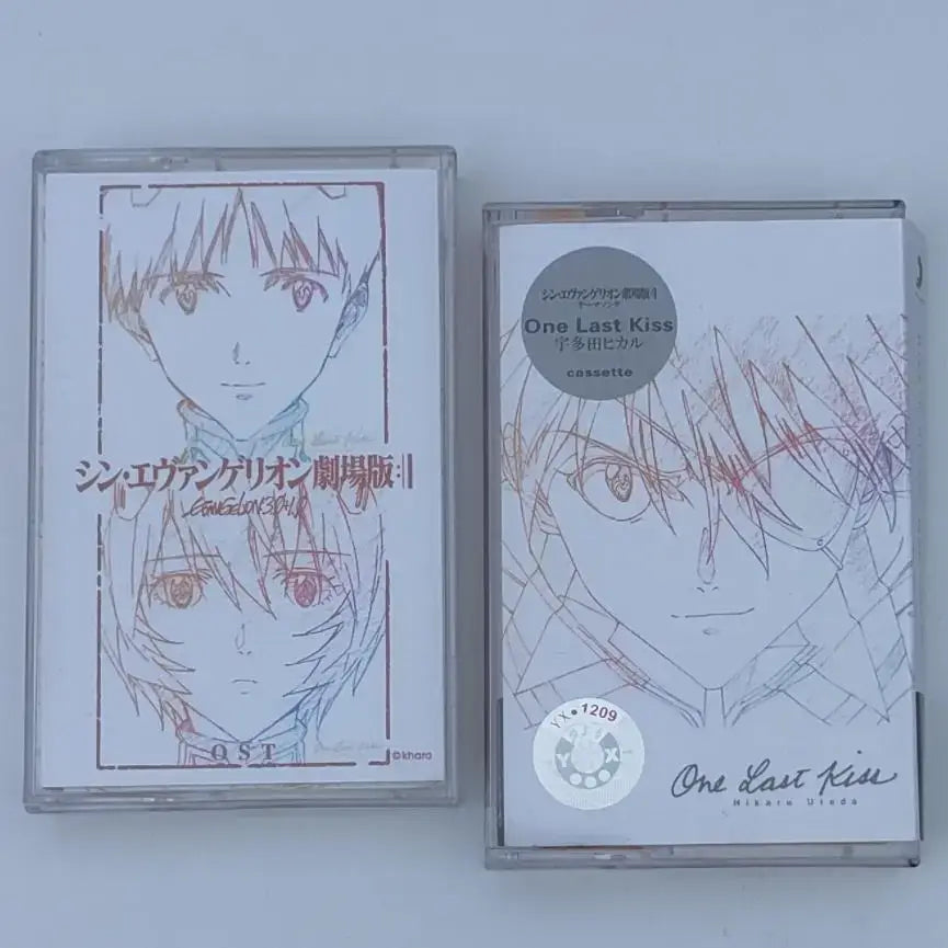 Two clear plastic cassette tapes featuring neon genesis evangelion asuka langley anime artwork and one last kiss soundtrack