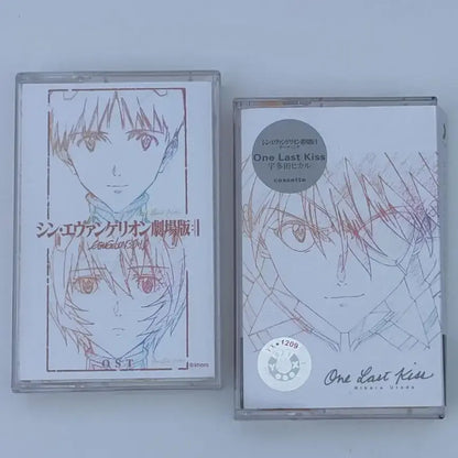Two clear plastic cassette tapes featuring neon genesis evangelion asuka langley anime artwork and one last kiss soundtrack