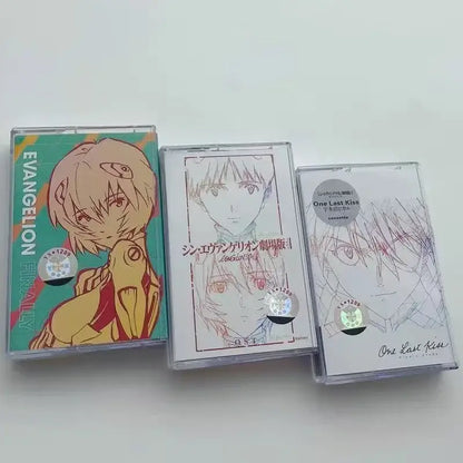 Three neon genesis evangelion anime-themed cassette tapes with colorful artwork and clear plastic cases for soundtrack use