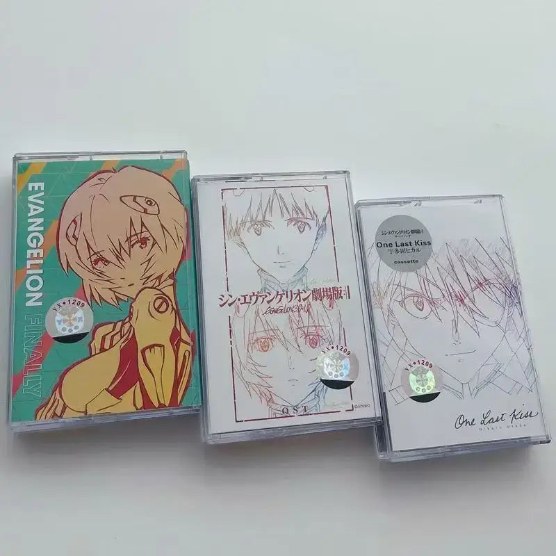 Three clear plastic cassette tapes with colorful neon genesis evangelion anime artwork from the sagisu shiro ost album