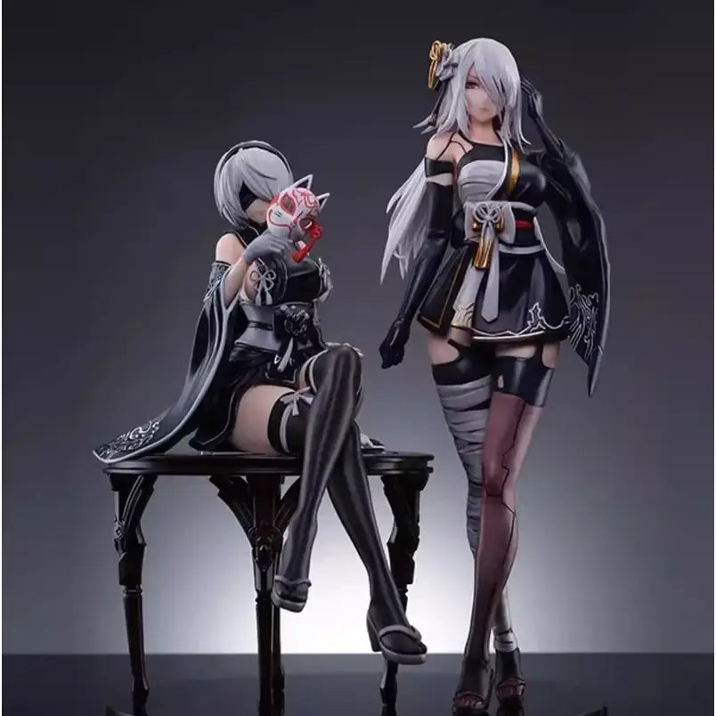 Black and white pvc anime girl figure of nier automata yorha no 2 type b in kimono seated holding red mask on dark table