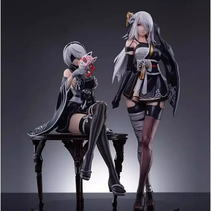 Black and white pvc anime girl figure of nier automata yorha no 2 type b in kimono seated holding red mask on dark table