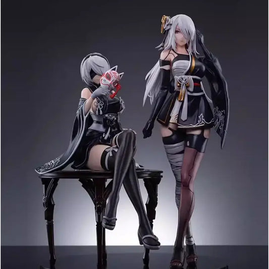 Black and white pvc anime girl figure of nier automata yorha no 2 type b in kimono seated holding red mask on dark table