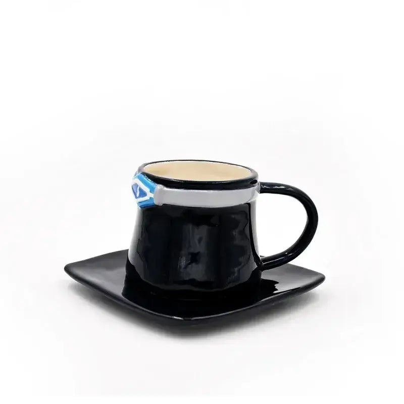 Black ceramic cup with silver and blue superman logo band on a matching black ceramic cup and saucer set