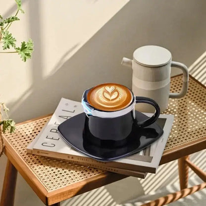 Black ceramic coffee cup with glossy finish and intricate latte art from one piece luffy ace sabo hat-shaped mug set