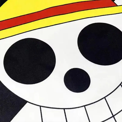 White skull with black eye sockets and toothy grin wearing yellow straw hat on one piece luffy pirate flag banner wall decor